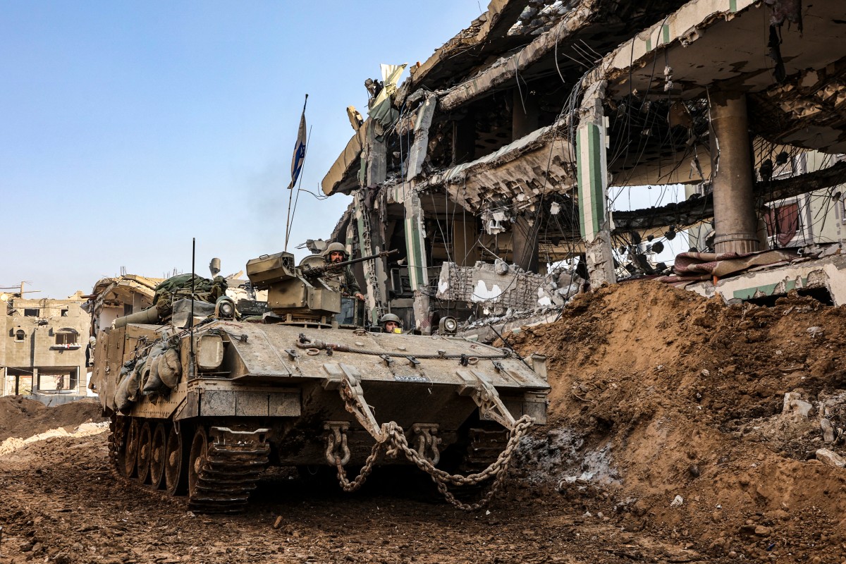 UN Security Council to vote on Gaza aid as famine fears mount - This picture taken on December 19, 2023, shows an Israeli tank rolling past damaged buildings during a military operation in the north of the Gaza Strip. (Photo by GIL COHEN-MAGEN / AFP)