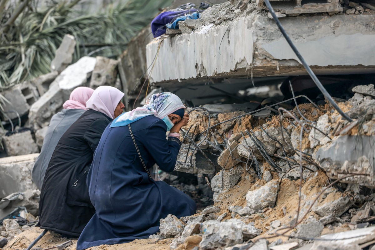 In Gaza, displaced women recount lives upended by war - Palestinian women cry where a relative is believed to be trapped in debris following Israeli bombardment in Rafah in the southern Gaza Strip on December 21, 2023. (Photo by MOHAMMED ABED / AFP)