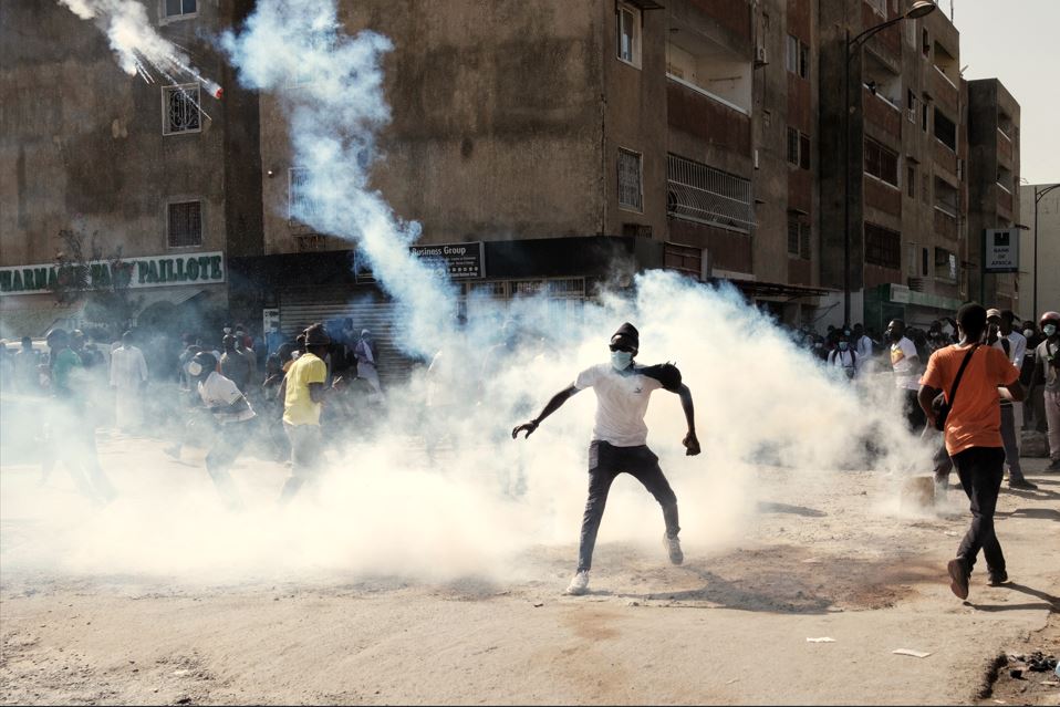 Student becomes first death in growing Senegal election protests - A protester throws back a tear gas canister during clashes with police on the sidelines of a protest against a last-minute delay of presidential elections in Dakar on February 9, 2024. (Photo: Guy Peterson/AFP)