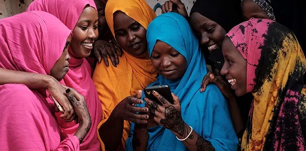 Northeastern region leads country in internet accessibility - Report - Young Somali women look at a smartphone at Dadaab refugee complex, in Garissa County. (Photo: Yasuyoshi Chiba/AFP/Getty Images)