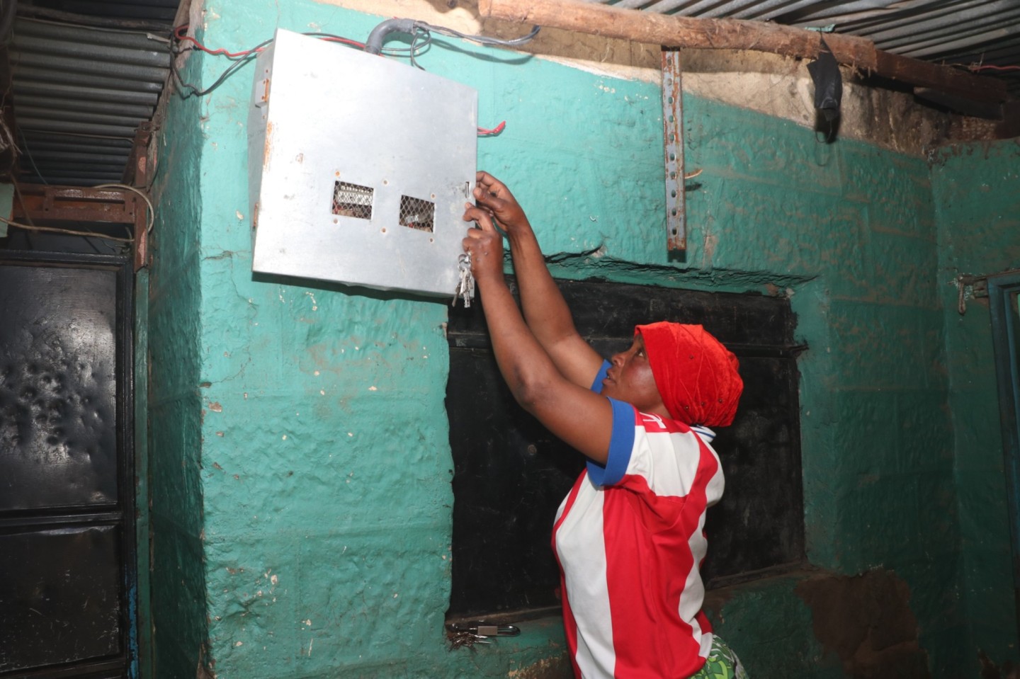 Amina Ramadhan closes a Kenya Power meter box. (Photo: Justine Ondieki)
