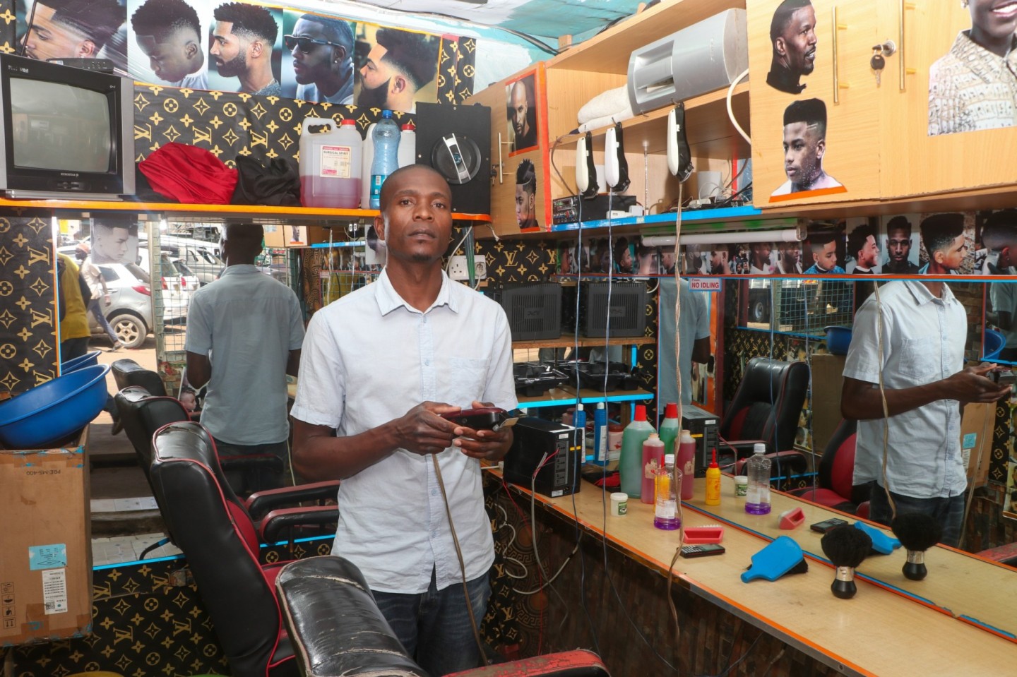Dennis Iganga, a barbershop owner in Mombasa Ndogo, Shauri Moyo, stands in an empty shop on Monday, May 27, due to a month-long electricity blackout. (Photo: Justine Ondieki) 