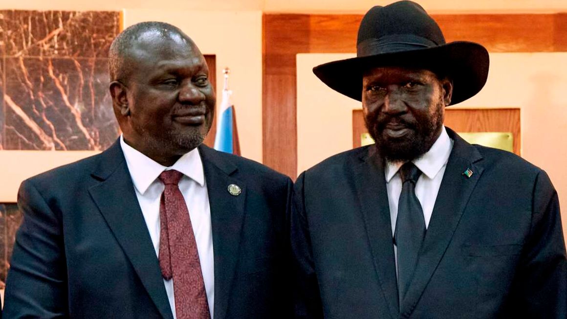 South Sudanese President Salva Kiir (R) shakes hands with First Vice President Riek Machar as he ttends his swearing-in ceremony at the State House in Juba,on February 22, 2020, South Sudan. - South Sudan rebel leader Riek Machar was sworn in as first vice president on February 22, 2020, formally rejoining the government in the latest bid to bring peace to a nation ravaged by war. Machar has been sworn in following years of civil war between his SPLA-IO and President Salva Kiir’s SPLA, leaving 400,000 South Sudanese dead. (Photo by ALEX MCBRIDE / AFP)