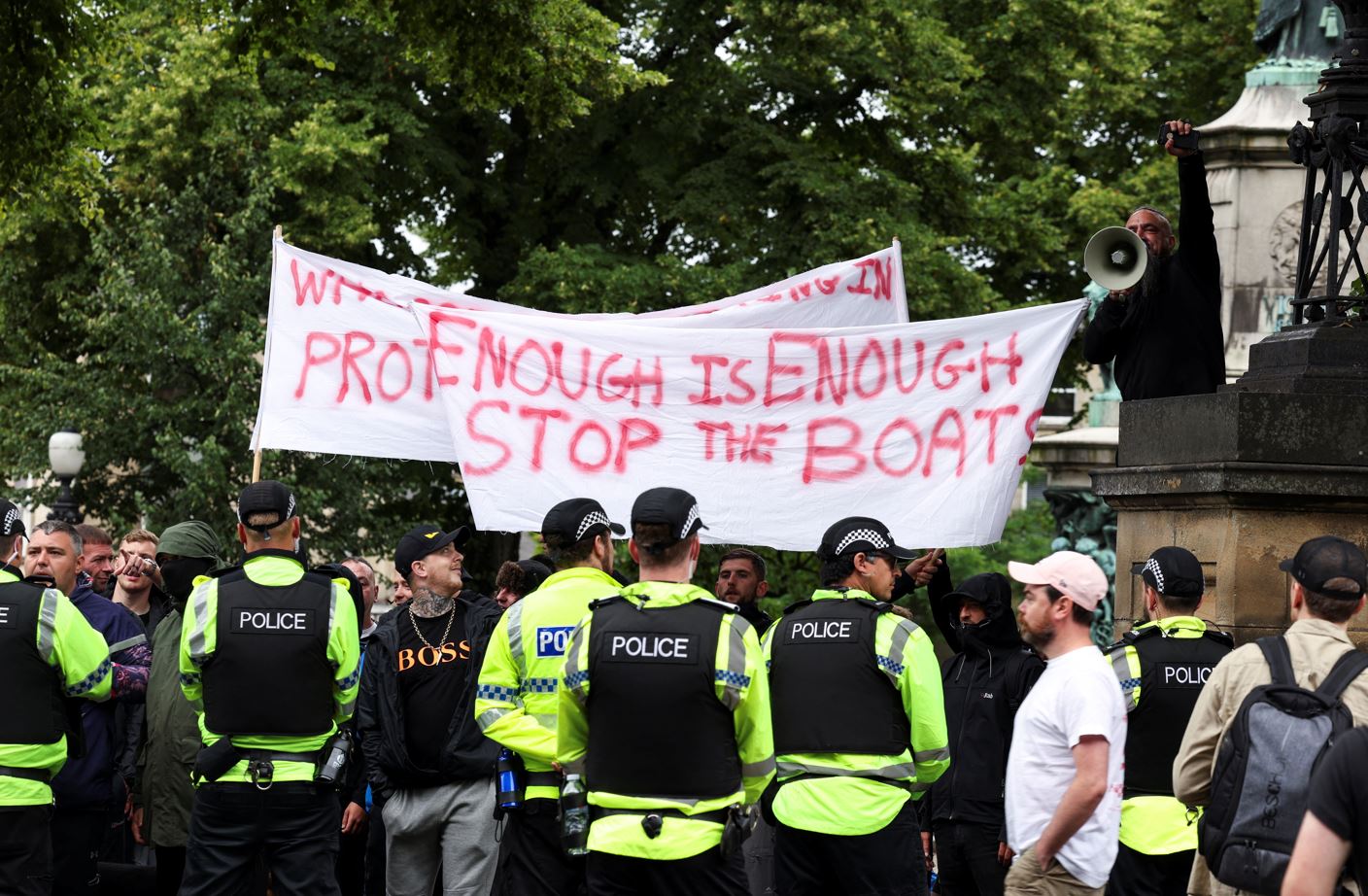 Police officers stand guard, as people take part in an anti-immigration protest in Lancaster, Britain, August 4, 2024. REUTERS/Manon Cruz