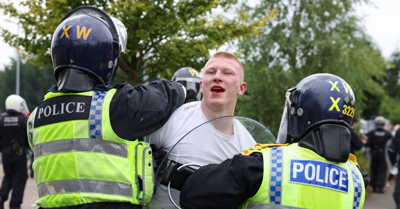 Police officers detain a man as people protest outside a hotel in Rotherham, Britain, August 4, 2024. (Photo: REUTERS/Hollie Adams)