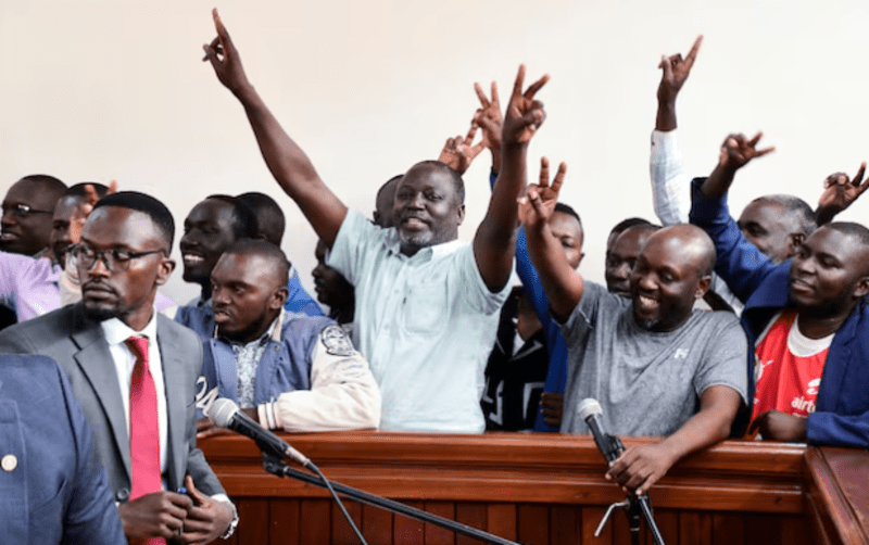 Ugandan opposition members face 'terrorism' charges - Ugandan opposition supporters gesture in the dock where they were charged with terrorism-related offences, after they were deported from neighbouring Kenya, where they had traveled to attend a training course in Kisumu, at the Nakawa Chief Magistrates court in Kampala, Uganda July 29, 2024. (Reuters)