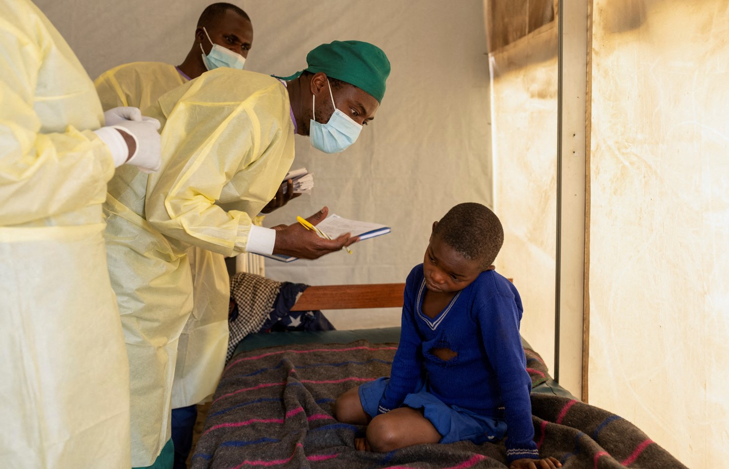 Dr. Tresor Wakilongo, verifies the evolution of skin lesions on the ear of Innocent, suffering from Mpox - an infectious disease caused by the monkeypox virus that sparks off a painful rash, enlarged lymph nodes and fever; at the treatment centre in Munigi, following Mpox cases in Nyiragongo territory near Goma, North Kivu province, Democratic Republic of the Congo July 19, 2024. (Photo: REUTERS/Arlette Bashizi/File Photo)