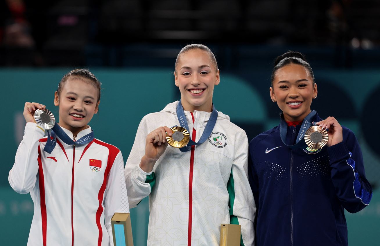 Paris 2024 Olympics - Artistic Gymnastics - Women's Uneven Bars Victory Ceremony - Bercy Arena, Paris, France - August 04, 2024. Gold medallist Kaylia Nemour of Algeria celebrates on the podium with silver medallist Qiyuan Qiu of China and bronze medallist Sunisa Lee of United States. (Photo: REUTERS/Mike Blake)