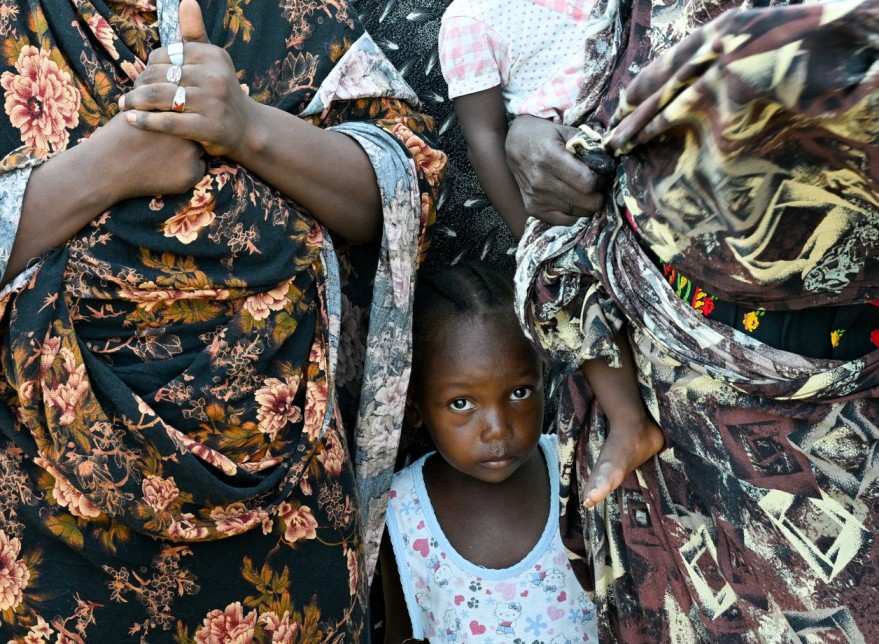 A child stands between two women at a school turned into a shelter, in Port Sudan, Sudan, August 29, 2024. (Photo: REUTERS/Abrahim Mohammed Ishac)