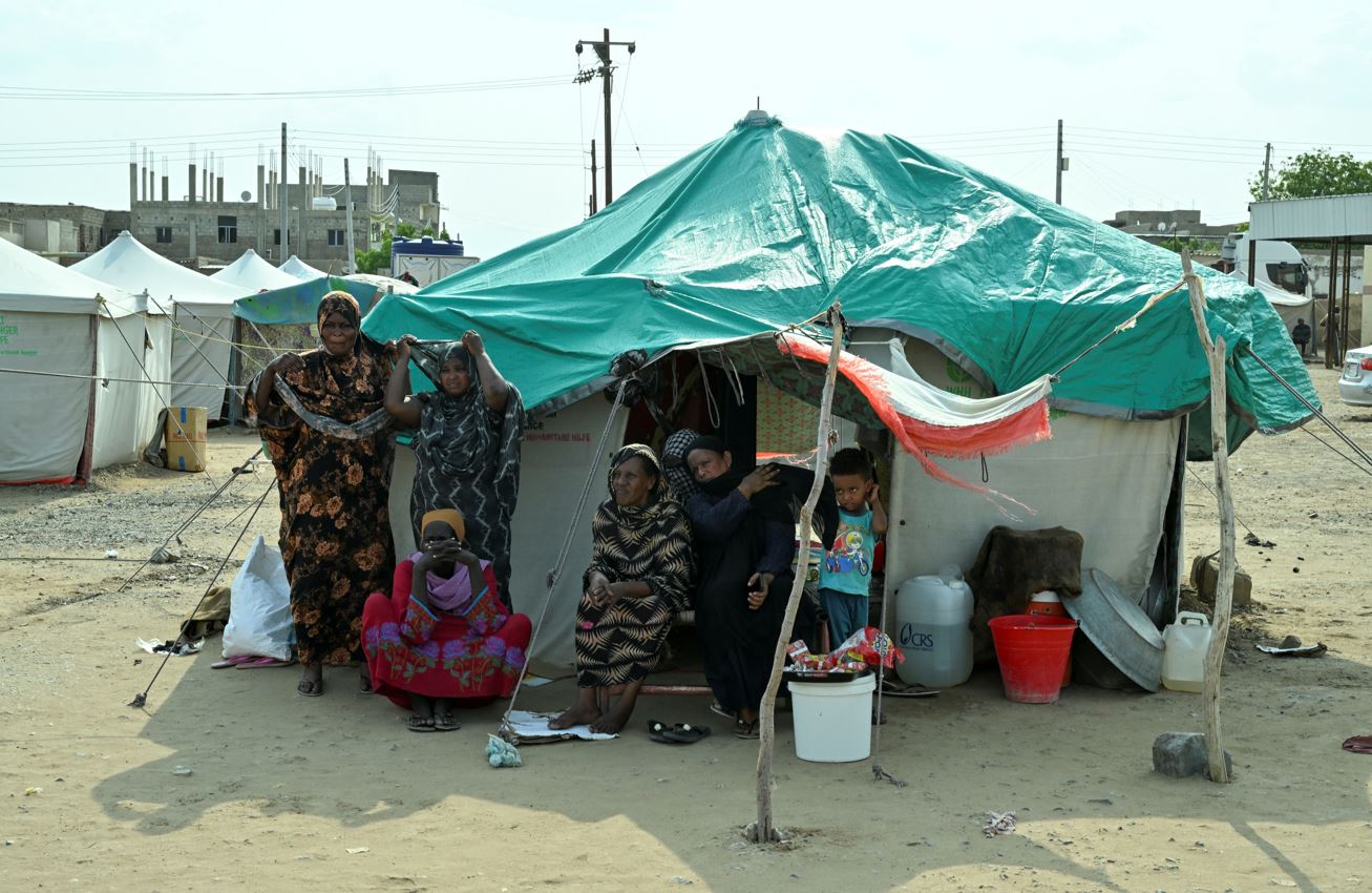 Displaced women, accompanied by a child, sit and stand outside a makeshift tent at a school turned into a shelter, in Port Sudan, Sudan, August 29, 2024. (Photo: REUTERS/Abrahim Mohammed Ishac)