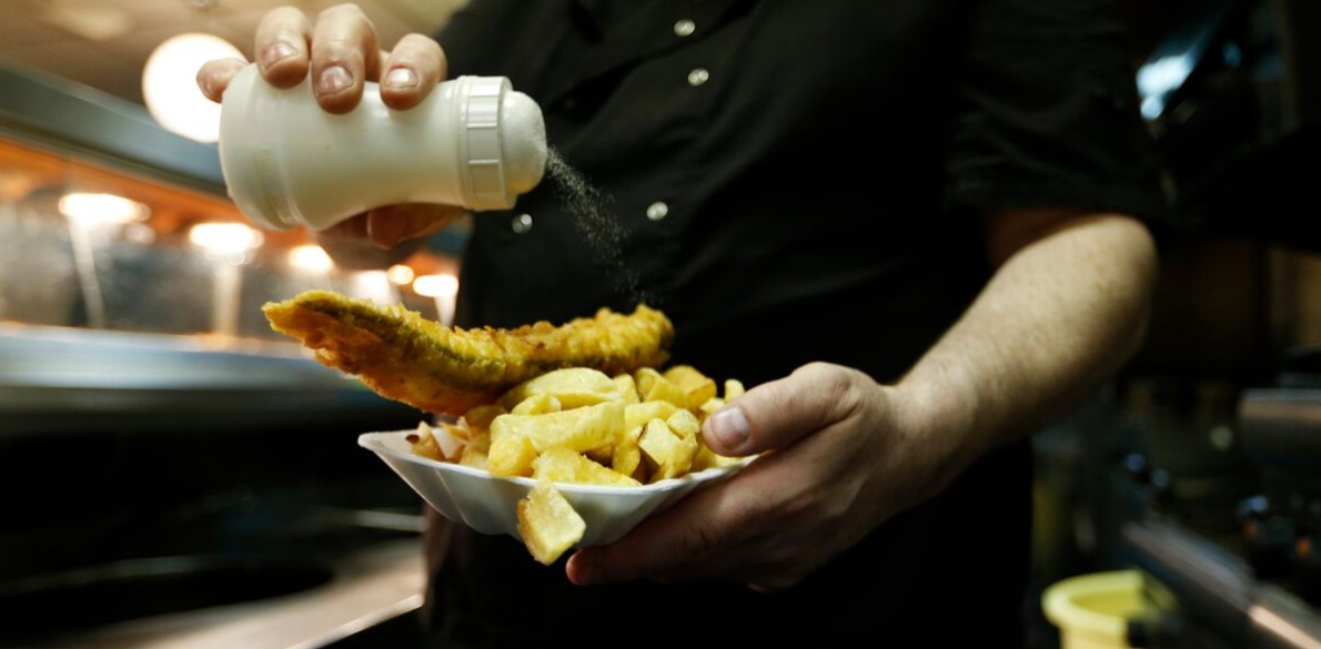 Step-by-step guide: How to reduce food waste at home - A man adds salt to a plate of fish and chips. (Photo: REUTERS/Eddie Keogh)