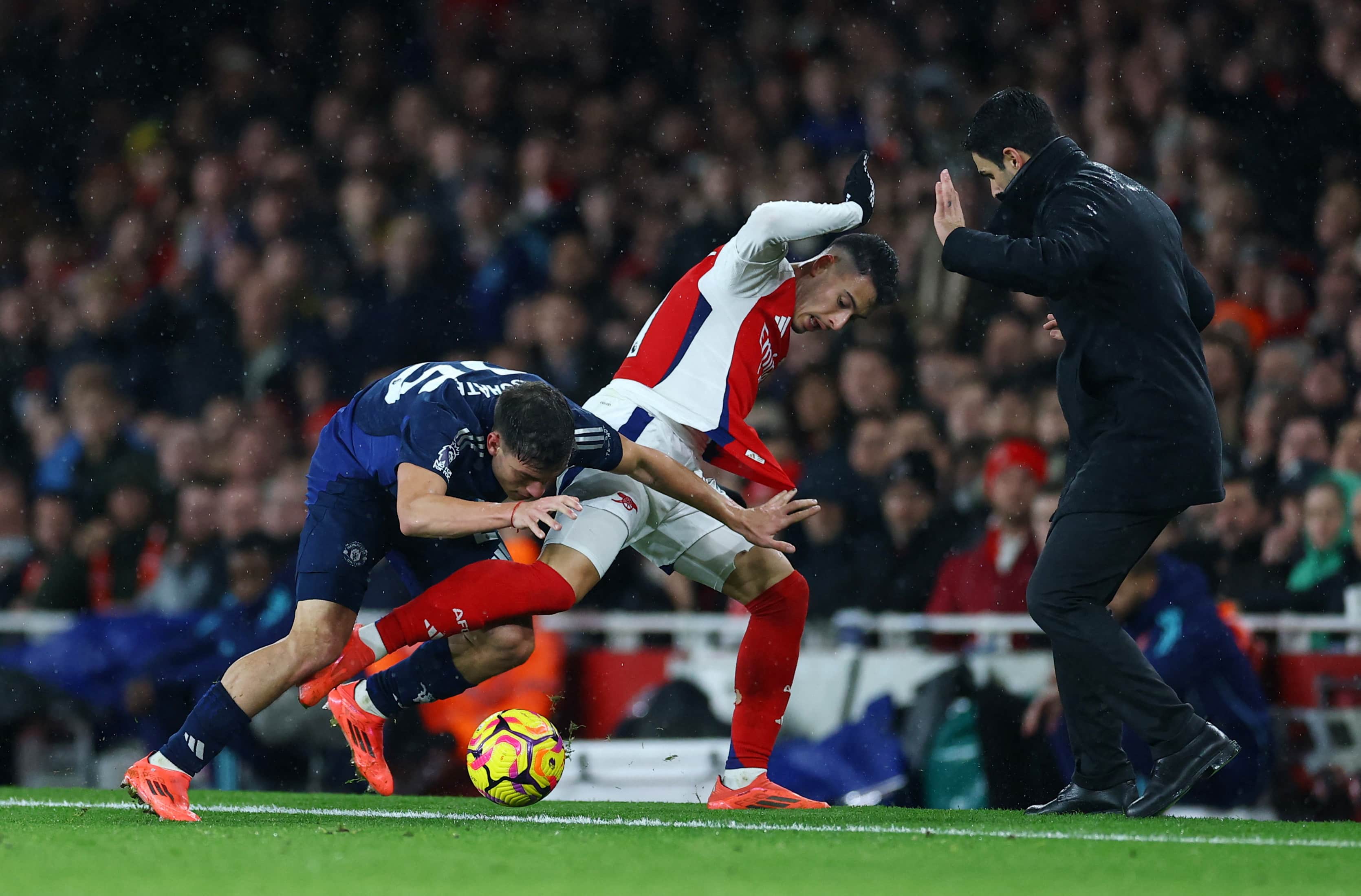 Arsenal boss Arteta hails 'will to win' after downing Manchester United - Manchester United's Manuel Ugarte in action with Arsenal's Gabriel Martinelli as Arsenal manager Mikel Arteta looks on Action Images via Reuters/Matthew Childs