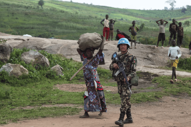 UN peacekeepers guard Congolese farmers working their fields