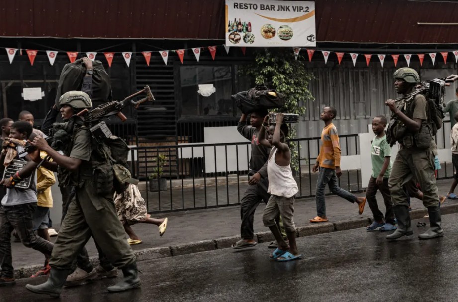 M23 rebels hand over 288 mercenaries to Rwanda as they take full control of Goma - Members of the M23 armed group walk alongside residents in a street of the Keshero neighborhood in Goma on January 27, 2025. (Photo: STR/AFP)