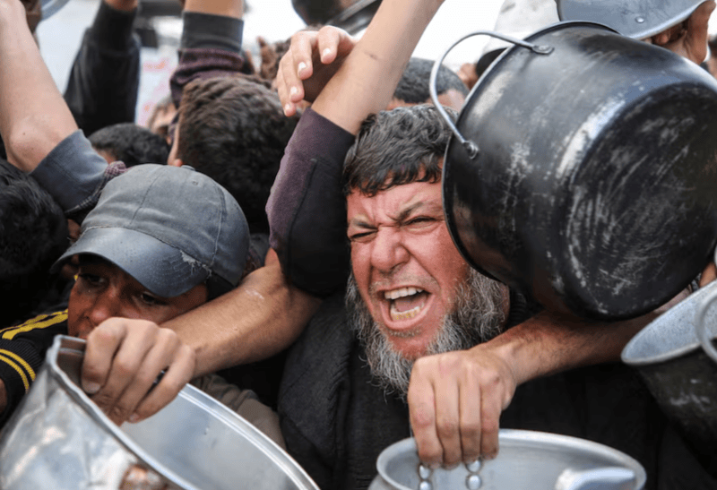 Flooding Gaza with aid might lessen security challenge, says UNRWA chief - Palestinians gather to receive food cooked by a charity kitchen, before a ceasefire between Hamas and Israel takes effect, in Khan Younis, in the southern Gaza Strip, January 17, 2025. REUTERS