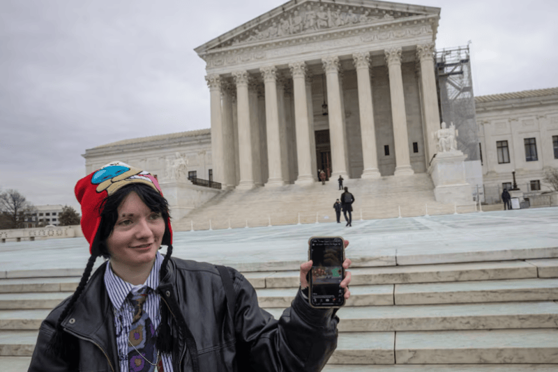 TikTok restores service, thanks Trump - A woman shows her TikTok feed in front of the U.S. Supreme Court in Washington, U.S., January 17, 2025. REUTERS