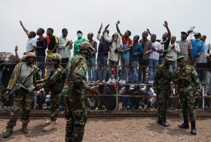 Congo Conflict: M23 warns of escalating violence against civilians - M23 rebels stand guard near civilians during a meeting organised by the M23 at the Stade de l'Unite, after the town of Goma was taken by the M23 rebels, in Goma, Democratic Republic of Congo, February 6, 2025. (Photo: REUTERS/Arlette Bashizi)